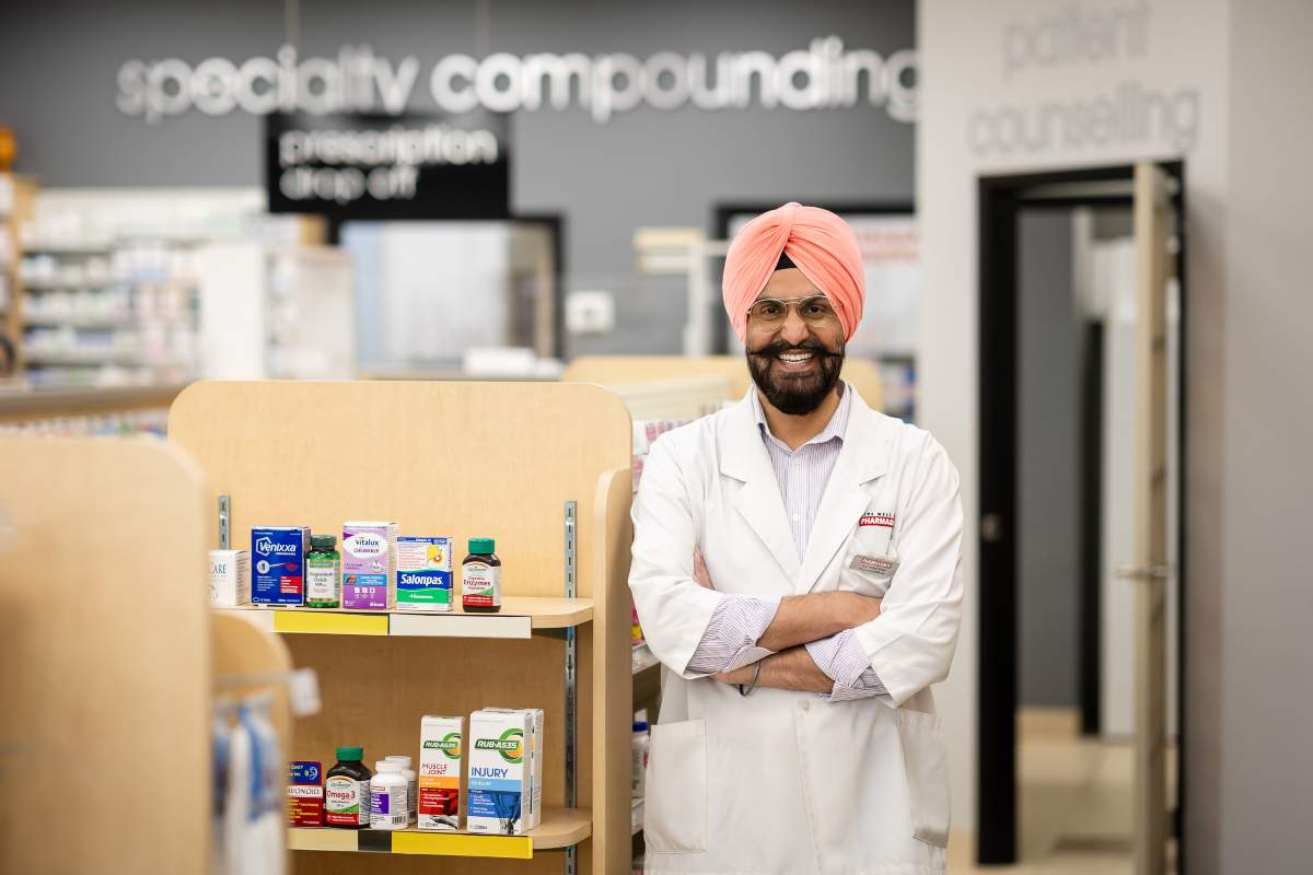 Gurinder Brar, the pharmacist at Fairway Lackner Pharmacy stands smiling with arms crossed in his Kitchener pharmacy.